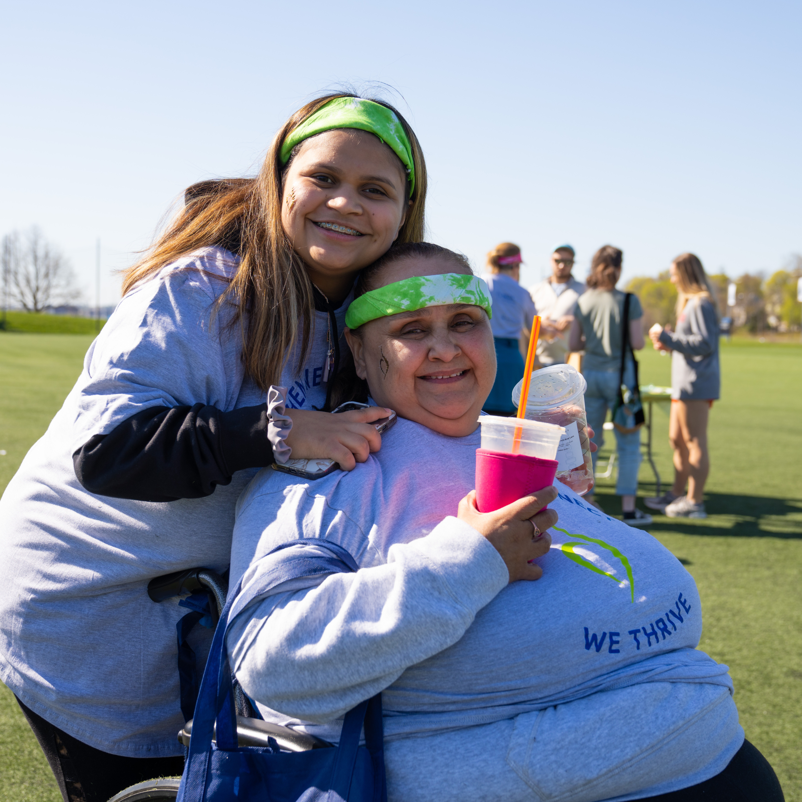Donating to support those affected by eating disorder like these Two women, wearing Green bandanas and NEDA t-shirts smiling at the camera.